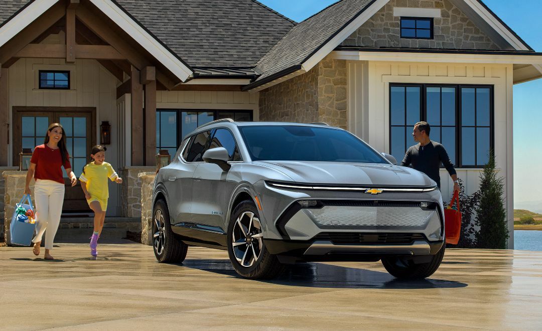 A Family of Three Walking From the House to a Parked Chevrolet Equinox EV